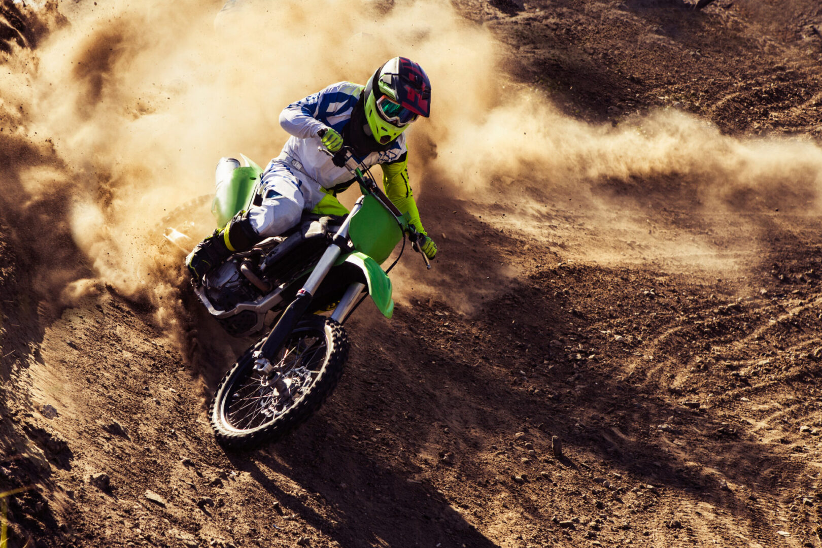 Motocross rider creates a large cloud of dust and debris